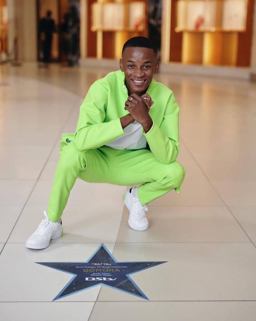 Image of Sicelo Buthelezi in front of a Dstv Star award!